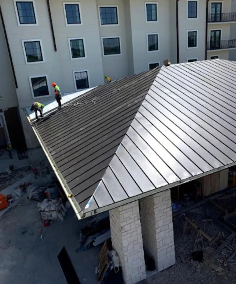 Crew installing standing seam metal roof panels on a commercial project in Fairwood
